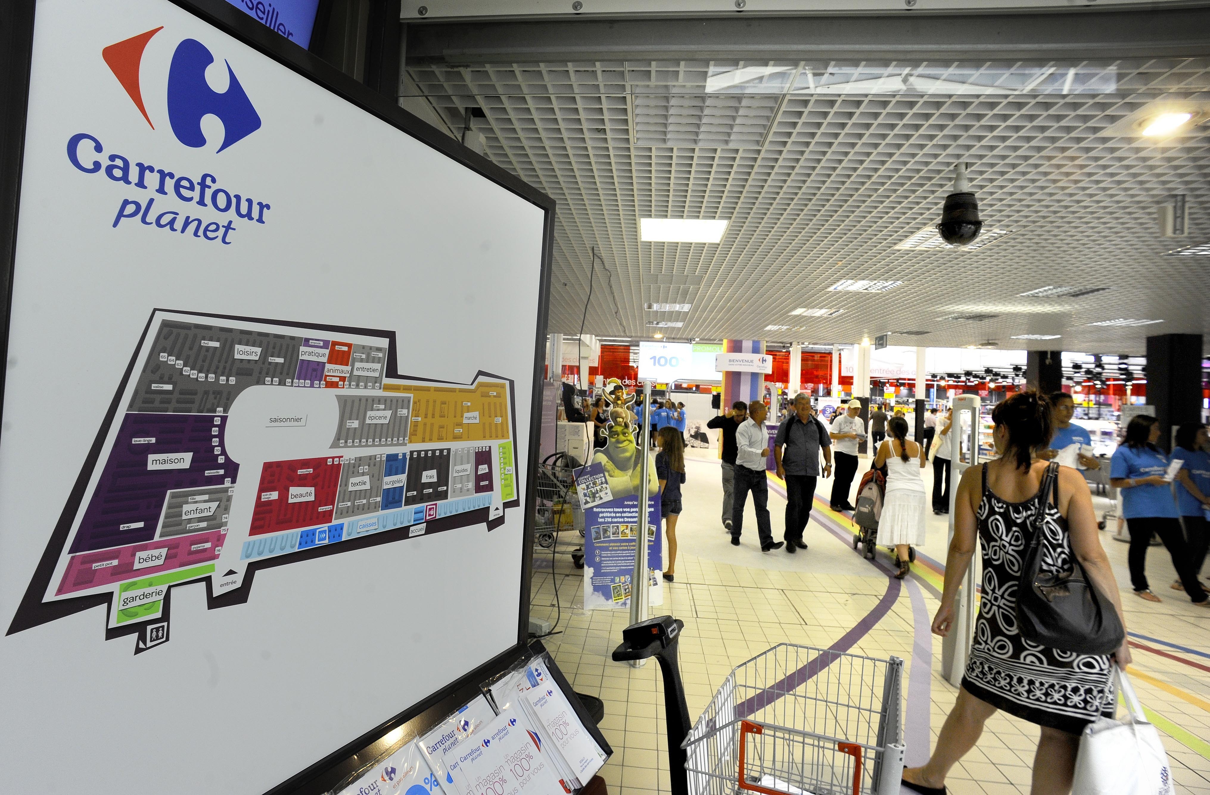 FILE - Shoppers enter the new Carrefour store Wednesday Aug. 25, 2010 in Ecully, near Lyon, central France. Carrefour has unveiled its hypermarket reinvention project at two stores in Lyon. The Ecully and Venissieux host the Carrefour Planet concept. The stores split into nine zones, including a 'discovery' store for events and seasonally themed products. (AP Photo/Thomas Campagne, File)